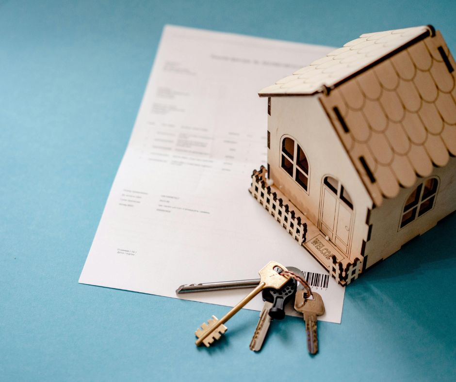 A wooden toy house sitting on loan paperwork
